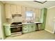 Kitchen featuring stainless steel appliances, sage colored cabinets, and white countertops at 5206 Westhill Nw Dr, Norcross, GA 30071