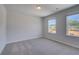 Bedroom featuring neutral carpet, two large windows, and light gray walls at 132 Dalston Cv, Stockbridge, GA 30281