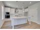Bright kitchen features a large island, stainless steel appliances, pendant lighting and hardwood floors at 132 Dalston Cv, Stockbridge, GA 30281