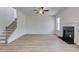 Living room featuring a fireplace, staircase, large windows, hardwood floors, and light gray walls at 132 Dalston Cv, Stockbridge, GA 30281