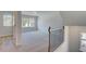 A large loft area with neutral carpet, several windows, and an open view of the staircase at 132 Dalston Cv, Stockbridge, GA 30281