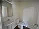 Cozy bathroom features a white pedestal sink, toilet and a stylish mirror at 2417 Overlook Ave, Lithonia, GA 30058