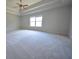 Spacious main bedroom with a tray ceiling, ceiling fan, and lots of natural light at 2417 Overlook Ave, Lithonia, GA 30058