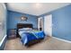 Blue bedroom with a modern design and well lit by a large window and a white door at 1921 Boulder Gate Dr, Ellenwood, GA 30294