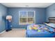 Charming bedroom with blue walls and a large window overlooking the front yard at 1921 Boulder Gate Dr, Ellenwood, GA 30294