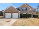 Two-story brick home featuring a two-car garage and well-maintained landscaping at 1921 Boulder Gate Dr, Ellenwood, GA 30294