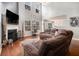 Open living room with a fireplace, hardwood floors, and a comfortable brown sectional couch at 1921 Boulder Gate Dr, Ellenwood, GA 30294