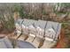 An aerial view of the brick and siding townhomes showcasing landscaping, attached garages and proximity to a green space at 2363 Palladian Manor Se Way # 4, Atlanta, GA 30339