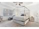 A light and airy bedroom with a tray ceiling, silver canopy bed, and natural light from the window at 2363 Palladian Manor Se Way # 4, Atlanta, GA 30339