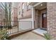 Brick townhome entrance featuring manicured landscaping and a black wrought iron fence at 2363 Palladian Manor Se Way # 4, Atlanta, GA 30339