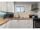 Sunlit kitchen with light wood counters, stone backsplash, and white cabinets at 5558 Kingsport Dr # 27, Atlanta, GA 30342