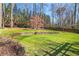 A spacious, well-maintained backyard with a decorative rock wall and mature trees providing ample shade at 933 Vistavia Cir, Decatur, GA 30033