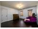 Bright bedroom with dark wood floors, natural light, purple chaise and a decorative armoire at 1435 Jay Ct, Snellville, GA 30078