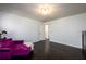 Simple bedroom with dark wood floors, white walls, and a purple chaise lounge at 1435 Jay Ct, Snellville, GA 30078