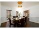 Formal dining room featuring hardwood floors, wainscoting, and modern lighting fixture at 1435 Jay Ct, Snellville, GA 30078