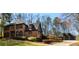 Brick home with manicured landscaping and a detached garage with a gable roof amid bare trees in winter at 1435 Jay Ct, Snellville, GA 30078