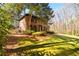 Side view of a two-story brick home with lush green lawn and mature trees at 1435 Jay Ct, Snellville, GA 30078