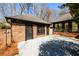 Exterior shot of a detached brick garage with black trim and adjacent building with sunroom at 1435 Jay Ct, Snellville, GA 30078