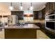 Modern kitchen featuring a large island with a cooktop and stainless steel appliances at 1435 Jay Ct, Snellville, GA 30078