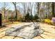 Backyard pool covered and surrounded by lush greenery, with a slide and lounge chair at 1435 Jay Ct, Snellville, GA 30078