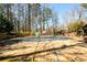 Large backyard with a swimming pool covered for the season, and tall surrounding trees at 1435 Jay Ct, Snellville, GA 30078