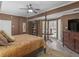 Primary bedroom featuring a four-poster bed, dresser with TV, and a bay window area at 2554 Emerald Dr, Jonesboro, GA 30236