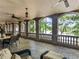 This covered stone patio with lake views features beautiful columns, stone arches, ceiling fans, and outdoor seating at 2554 Emerald Dr, Jonesboro, GA 30236