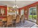 Elegant dining room features red walls, detailed molding, a chandelier, and windows offering bright natural light at 2554 Emerald Dr, Jonesboro, GA 30236