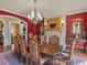 Formal dining room with red walls, a fireplace, and large wood table offers an elegant space for gatherings at 2554 Emerald Dr, Jonesboro, GA 30236