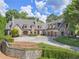 Charming stone home with a circular driveway, mature trees, and manicured shrubs at 2554 Emerald Dr, Jonesboro, GA 30236