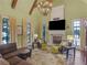 Bright living room featuring a vaulted ceiling, fireplace, and large windows overlooking the property at 2554 Emerald Dr, Jonesboro, GA 30236