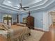 Serene main bedroom with a four-poster bed, blue walls, tray ceiling, and a view to the patio at 2554 Emerald Dr, Jonesboro, GA 30236