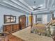 Well-appointed main bedroom with a four-poster bed, blue walls, tray ceiling, and classic wooden furniture at 2554 Emerald Dr, Jonesboro, GA 30236