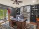 Office featuring a stone fireplace, dark trim, built-in bookcases, and large windows at 2554 Emerald Dr, Jonesboro, GA 30236