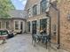 An outdoor patio with stone flooring and exterior of brick with black framed windows and outdoor seating at 2554 Emerald Dr, Jonesboro, GA 30236