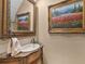 Elegant powder room featuring a decorative sink, ornate mirror, and a painting adds a touch of sophistication at 2554 Emerald Dr, Jonesboro, GA 30236