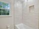 Bright bathroom featuring a soaking tub with tiled walls and built-in shelf at 2958 Cravey Ne Dr, Atlanta, GA 30345