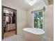 Bright bathroom featuring a soaking tub, large window, and access to a walk-in closet at 2958 Cravey Ne Dr, Atlanta, GA 30345