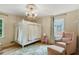 Cozy bedroom with a statement chandelier, natural light, and sitting area at 2958 Cravey Ne Dr, Atlanta, GA 30345