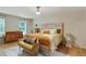 Bright bedroom features stylish furniture, a patterned headboard, and hardwood floors at 2958 Cravey Ne Dr, Atlanta, GA 30345