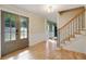Open foyer with hardwood floors, staircase with iron spindles, neutral paint, and glass panel front doors at 2958 Cravey Ne Dr, Atlanta, GA 30345