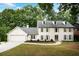 Charming two-story home with a manicured lawn, dormer windows, attached garage, and mature trees at 2958 Cravey Ne Dr, Atlanta, GA 30345