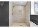Modern tiled shower featuring a rainfall showerhead and a recessed shelf for bath supplies at 4251 Canby Ln, Decatur, GA 30035