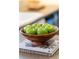 Close-up of apples in a wooden bowl sitting on top of books in a stylish kitchen setting at 4860 Roswell Mill Dr, Alpharetta, GA 30022