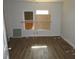 Empty bedroom with wood-look flooring, natural light, and boarded-up windows at 7 Whatley Se St, Atlanta, GA 30315