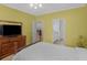 Yellow bedroom showcasing a traditional wood dresser, TV, and access to an ensuite bathroom at 740 Azalea Ave, Mcdonough, GA 30253