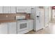 The kitchen features white appliances and cabinets with neutral countertops at 740 Azalea Ave, Mcdonough, GA 30253