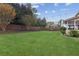 Spacious backyard featuring lush lawn, trees, a wooden fence, and string lights for outdoor entertaining at 3975 Silverthorn Trce, Cumming, GA 30028
