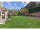 Large backyard featuring an expansive lawn, mature trees, landscape beds and a screened patio at 3975 Silverthorn Trce, Cumming, GA 30028
