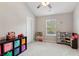 Neutral bedroom with window, neutral carpet and bookcase and play kitchen at 3975 Silverthorn Trce, Cumming, GA 30028